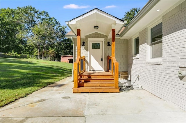 view of exterior entry featuring a lawn