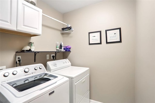 clothes washing area with washing machine and dryer and cabinets