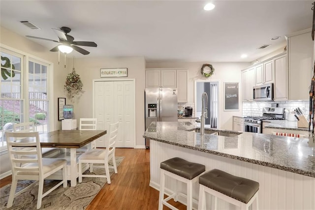 kitchen featuring light wood-type flooring, white cabinetry, sink, and appliances with stainless steel finishes