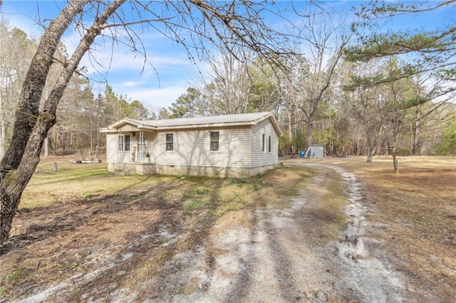 view of front of property featuring dirt driveway, metal roof, and crawl space