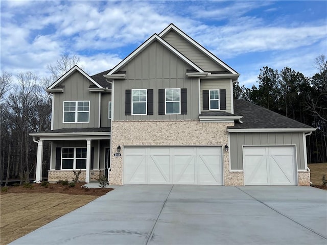 craftsman house featuring board and batten siding, brick siding, driveway, and a porch