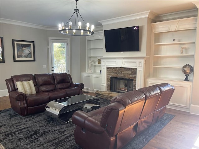 103 Mill Park Chase, Woodstock, GA 30188 - living area featuring wood finished floors, a chandelier, crown molding, built in shelves, and a stone fireplace
