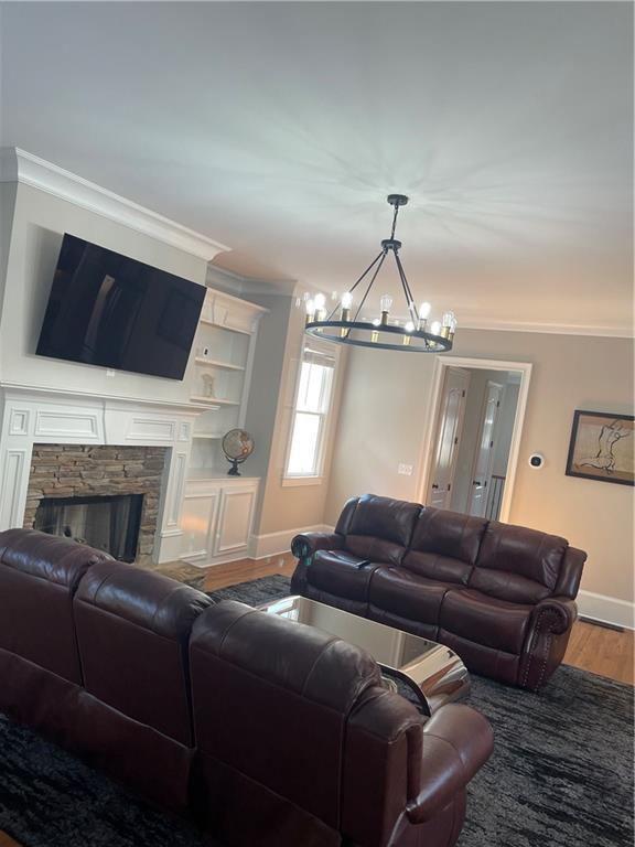 103 Mill Park Chase, Woodstock, GA 30188 - living area with a chandelier, crown molding, wood finished floors, and a fireplace