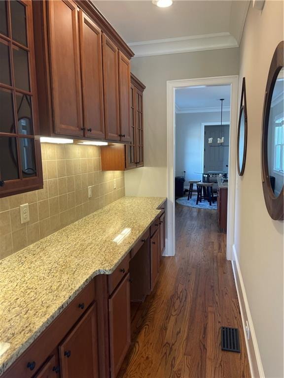 103 Mill Park Chase, Woodstock, GA 30188 - kitchen with dark wood-type flooring, light stone counters, decorative backsplash, and crown molding