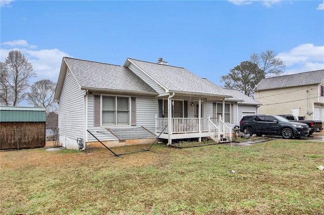 view of front facade with a front lawn, covered porch, and roof with shingles