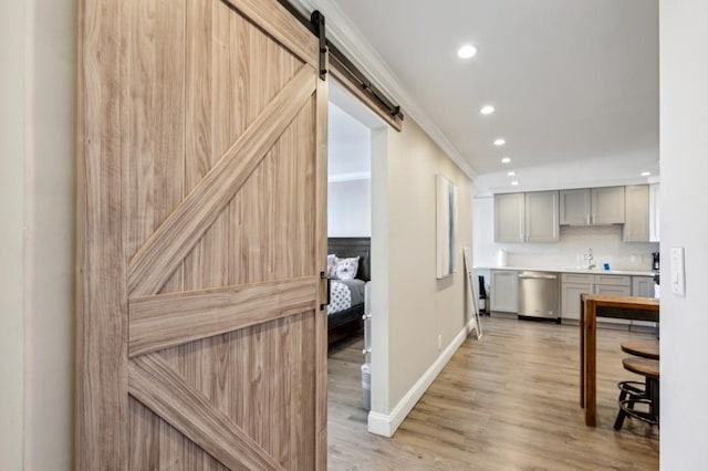 215 Piedmont Ave NE Unit 2103, Atlanta, GA 30308 - kitchen with gray cabinets, backsplash, light wood finished floors, a barn door, and stainless steel dishwasher