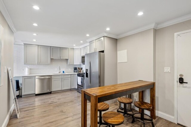 215 Piedmont Ave NE Unit 2103, Atlanta, GA 30308 - kitchen with gray cabinetry, ornamental molding, and stainless steel appliances