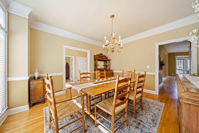 dining room featuring ornamental molding, a notable chandelier, and light hardwood / wood-style floors