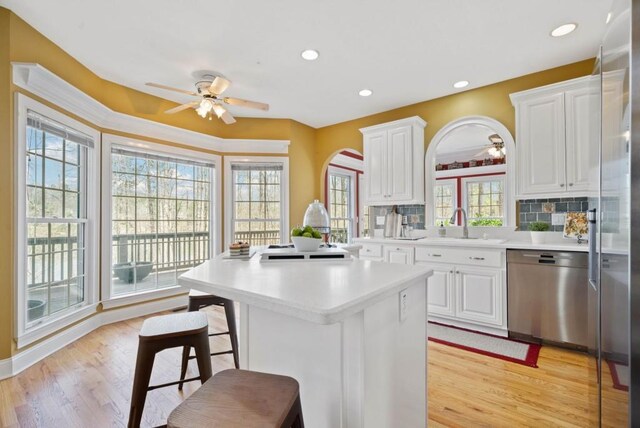 carpeted living room with crown molding, a towering ceiling, and ceiling fan