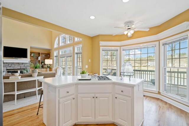 kitchen featuring white cabinetry, appliances with stainless steel finishes, a center island, and light wood-type flooring