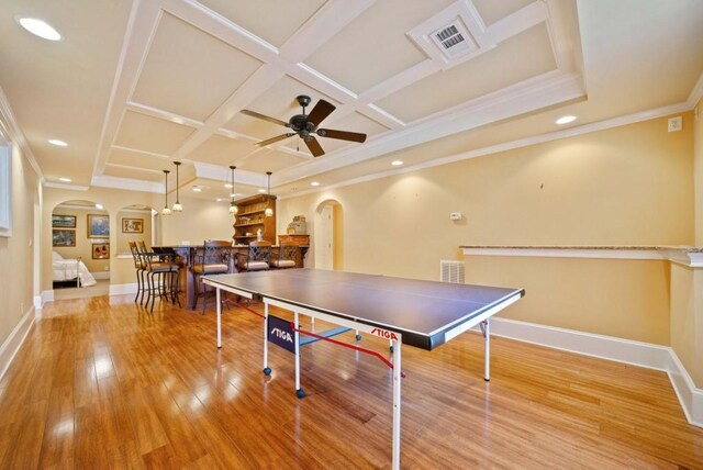 living room featuring a fireplace, ornamental molding, coffered ceiling, light tile patterned floors, and ceiling fan