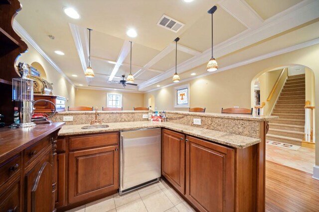 bar featuring pendant lighting, ornamental molding, coffered ceiling, and light hardwood / wood-style flooring