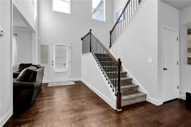 foyer entrance with dark wood-type flooring and a high ceiling