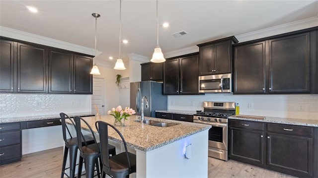 231 Malbone St SW, Cartersville, GA 30120 - kitchen with appliances with stainless steel finishes, a sink, an island with sink, ornamental molding, and light stone countertops
