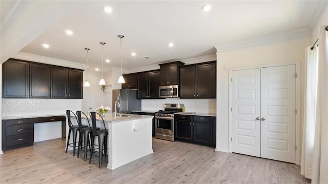 231 Malbone St SW, Cartersville, GA 30120 - kitchen with appliances with stainless steel finishes, a breakfast bar, ornamental molding, light wood-type flooring, and a center island with sink