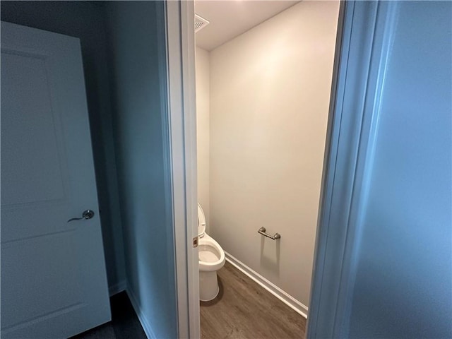 bathroom featuring hardwood / wood-style floors and toilet