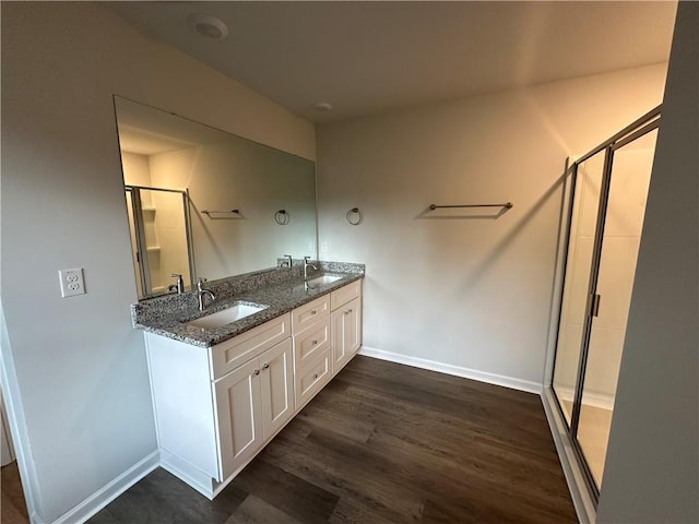 bathroom featuring wood-type flooring, a shower with shower door, and vanity