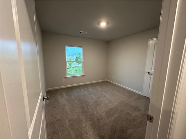 unfurnished room with dark colored carpet