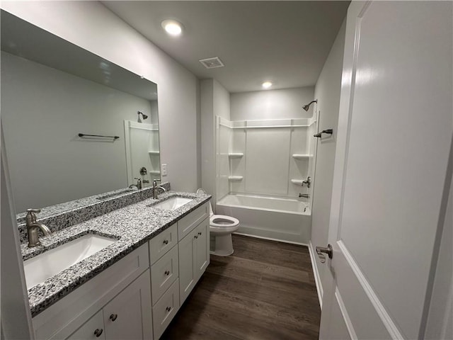 full bathroom featuring hardwood / wood-style floors, shower / bath combination, vanity, and toilet