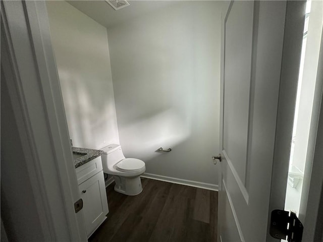 bathroom featuring vanity, toilet, and hardwood / wood-style flooring