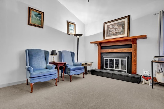 sitting room featuring lofted ceiling, carpet floors, and a glass covered fireplace