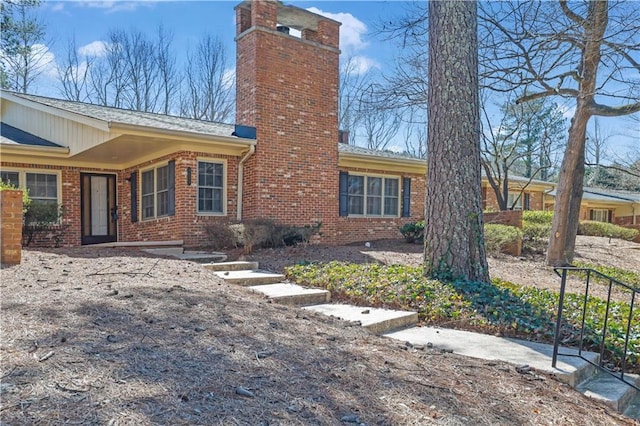 exterior space with brick siding and a chimney