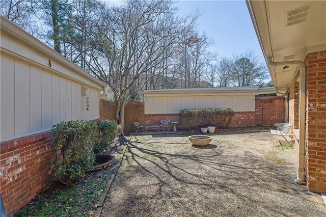 view of yard featuring a fire pit, a patio, fence, and visible vents