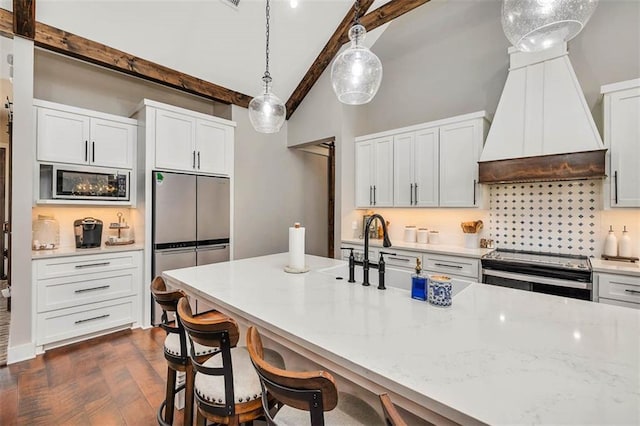 kitchen featuring stainless steel appliances, premium range hood, tasteful backsplash, white cabinets, and decorative light fixtures