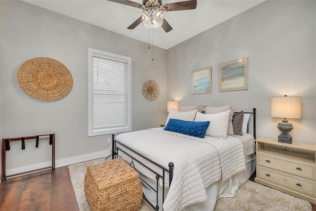 bedroom featuring wood finished floors, baseboards, and ceiling fan