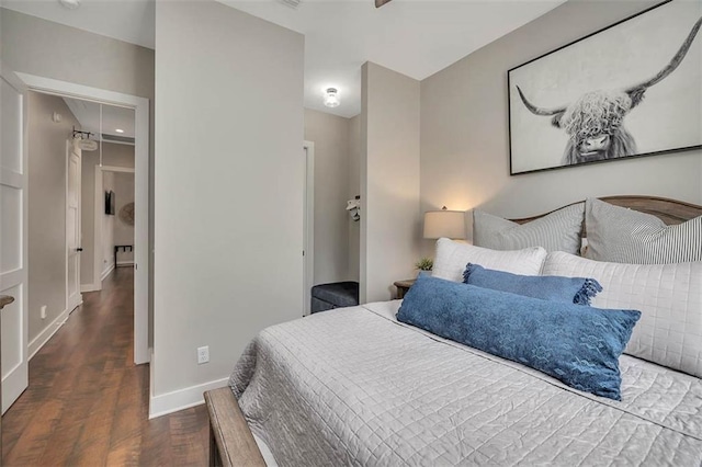bedroom featuring wood finished floors, baseboards, and attic access