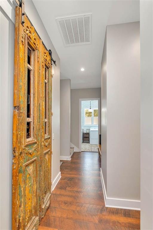 hall featuring baseboards, wood finished floors, recessed lighting, and washer / clothes dryer