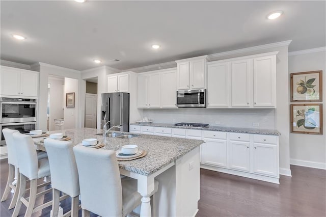 6179 Ashbranch Dr, Acworth, GA 30101 - kitchen with appliances with stainless steel finishes, a sink, crown molding, white cabinets, and a kitchen bar