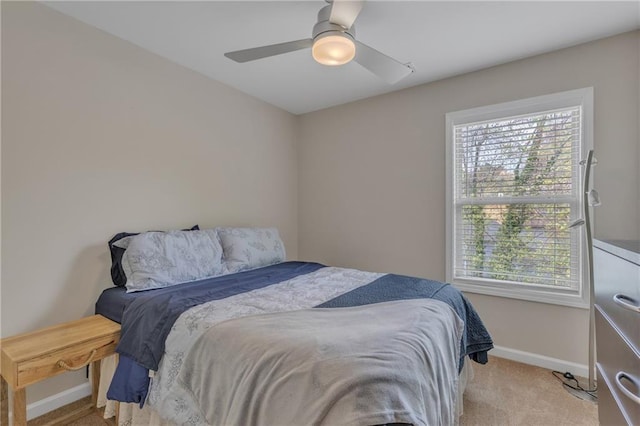 bedroom featuring a ceiling fan, light colored carpet, and baseboards