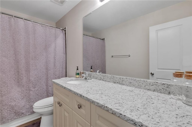 bathroom with toilet, visible vents, and vanity