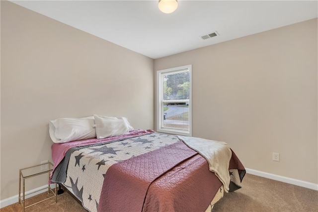 bedroom with carpet floors, visible vents, and baseboards