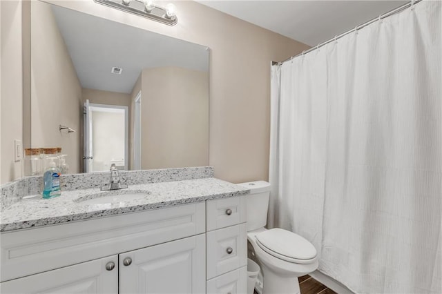 bathroom with a shower with curtain, vanity, and toilet