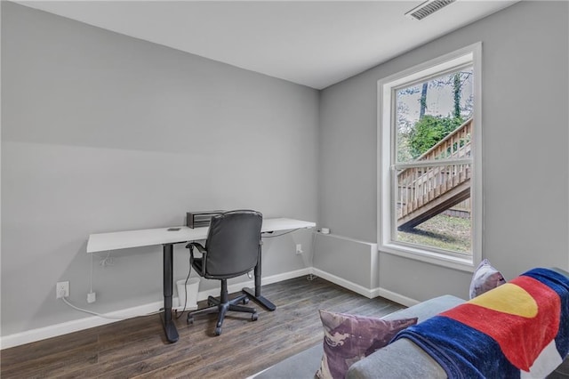 office with a wealth of natural light, visible vents, baseboards, and wood finished floors