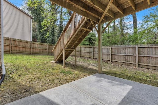 view of yard with a patio area, stairway, and a fenced backyard