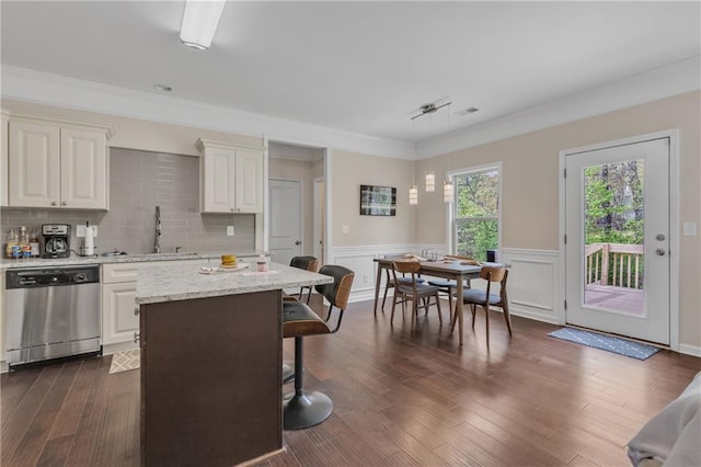 kitchen featuring dishwasher, dark wood-type flooring, wainscoting, and a sink