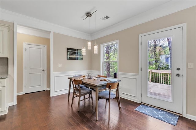 dining area with crown molding, wainscoting, visible vents, and dark wood finished floors