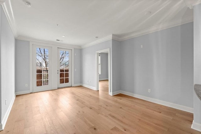 unfurnished room with ornamental molding, light wood finished floors, visible vents, and baseboards