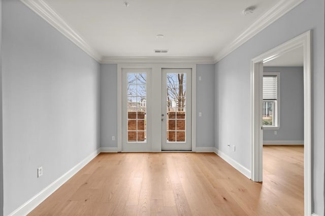 doorway to outside featuring ornamental molding, light wood-type flooring, visible vents, and baseboards