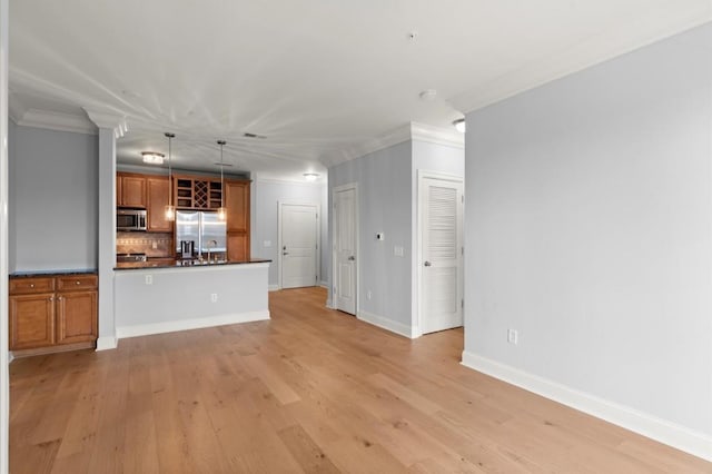 kitchen featuring light wood-style floors, appliances with stainless steel finishes, brown cabinets, tasteful backsplash, and dark countertops