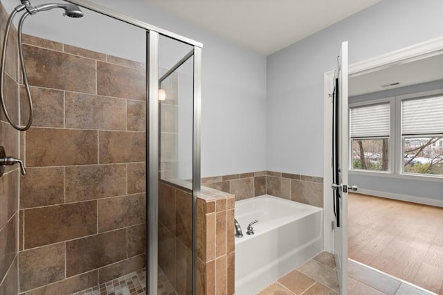 bathroom featuring a stall shower, a garden tub, and visible vents