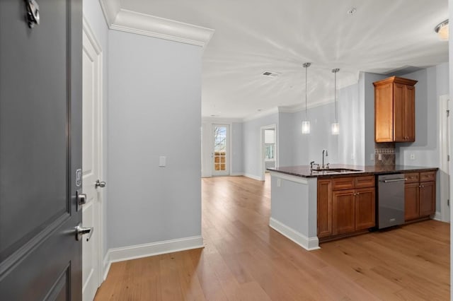 kitchen featuring brown cabinets, visible vents, stainless steel dishwasher, a sink, and light wood-type flooring