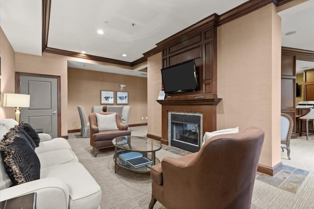 living area featuring light carpet, baseboards, crown molding, and a glass covered fireplace