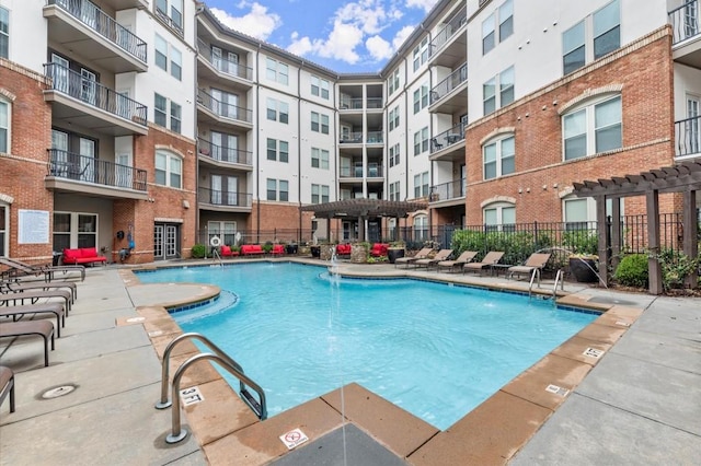 community pool with a patio area, fence, and a pergola