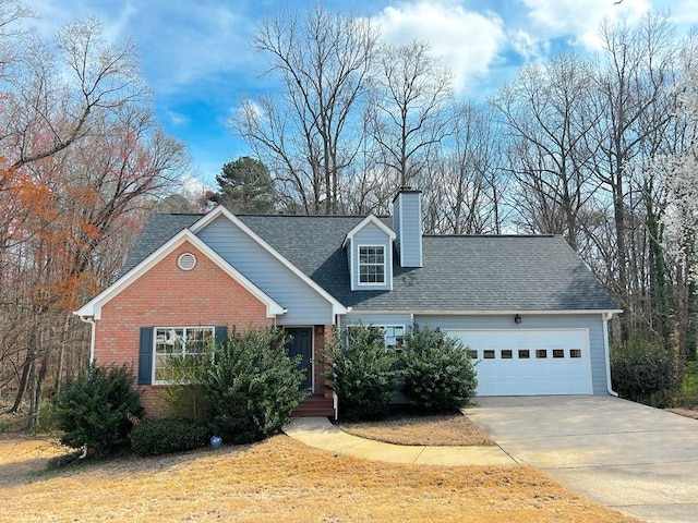 view of front of home featuring a chimney, concrete driveway, a garage, and brick siding