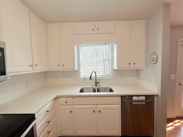 kitchen featuring a sink, dishwasher, white cabinets, and light countertops