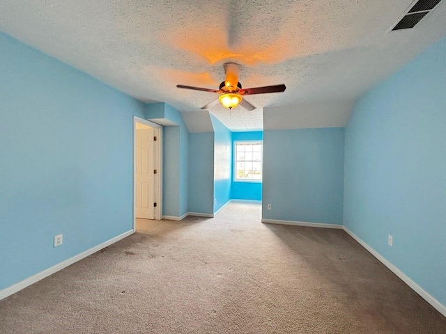 bonus room featuring baseboards, visible vents, carpet floors, ceiling fan, and a textured ceiling